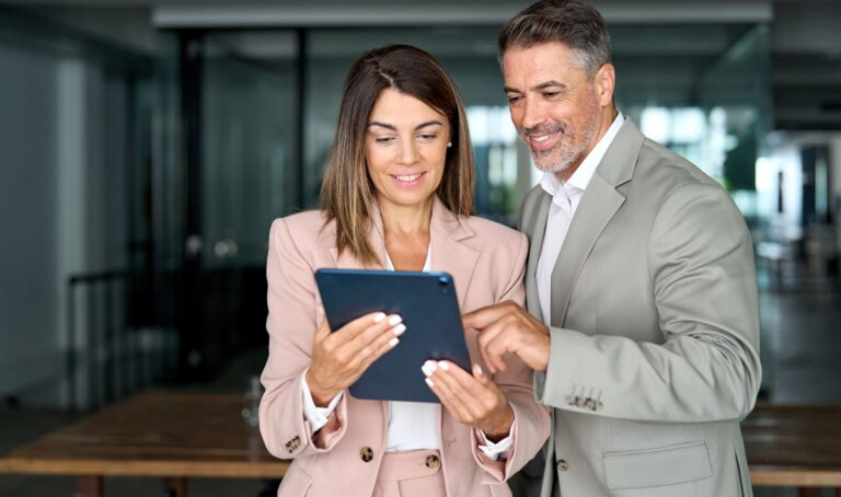 Zwei Geschäftspersonen betrachten ein Tablet bei der gemeinsamen OM Analyse.