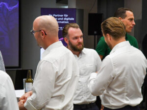 Personen besprechen am Event von Inacta die EMIL Insurance Suite